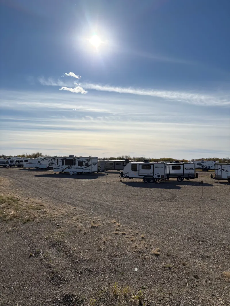 The gravel storage yard with trailers in the afternoon sun